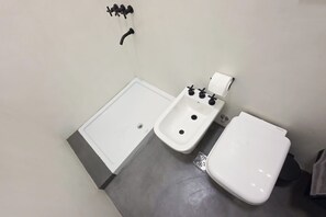 Ein Badezimmer mit einer Badewanne, einem Bidet und einer Toilette.