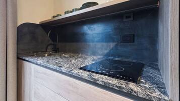 Una cocina con placa de inducción integrada y campana extractora de acero inoxidable.