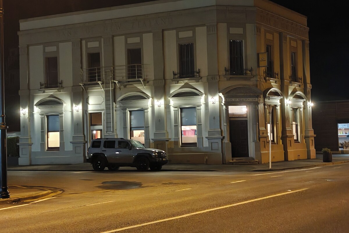 Um edifício com arquitetura clássica, apresentando uma fachada simétrica com janelas uniformemente distribuídas e uma entrada central.