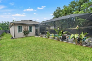 A house with a screened porch, a swimming pool, and a well-maintained lawn. - Heated Pool Getaway In Tampa Bay, Sleeps, Close to everything in Tampa Bay! (Tampa)