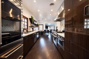 Een moderne keuken met roestvrijstalen apparatuur, donkerhouten keukenkastjes en een centraal eiland.