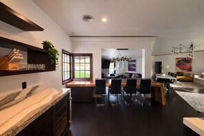 Een moderne keuken met een eethoek, een groot raam en een inbouwsbank.