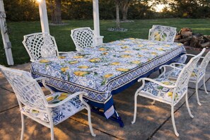 A patio with a table and chairs, surrounded by a garden. - Private Villa w/ Pool, Spa, Gym, Sauna, Spectacular Backyard, & 2 miles to Strip (Las Vegas)