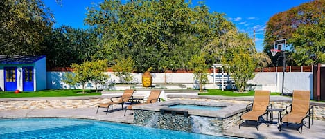 A swimming pool with lounge chairs and a Buddha statue.