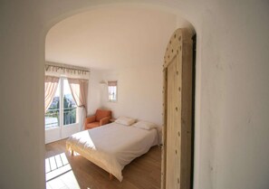 A bedroom with a bed, a chair, and a window with curtains. - Cabris, Mas provençal 6p, 3ch, AC, piscine, vue (Cabris)