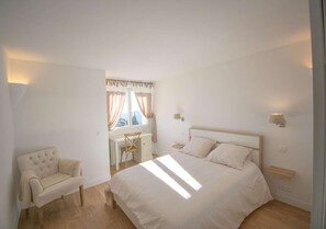 A bedroom with a bed, a chair, a desk, and a window with curtains. - Cabris, Mas provençal 6p, 3ch, AC, piscine, vue (Cabris)