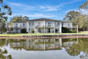 A two-story building with a flat roof, large windows, and balconies. - Duck Pond Villa at Hunter Valley Golf Resort Views (Lovedale)