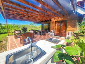 Eine Terrass mit Spüle, Stühlen und Tisch.