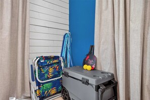Ein Zimmer mit blauer Wand, einem grauen Koffer und einer bunten Tasche.