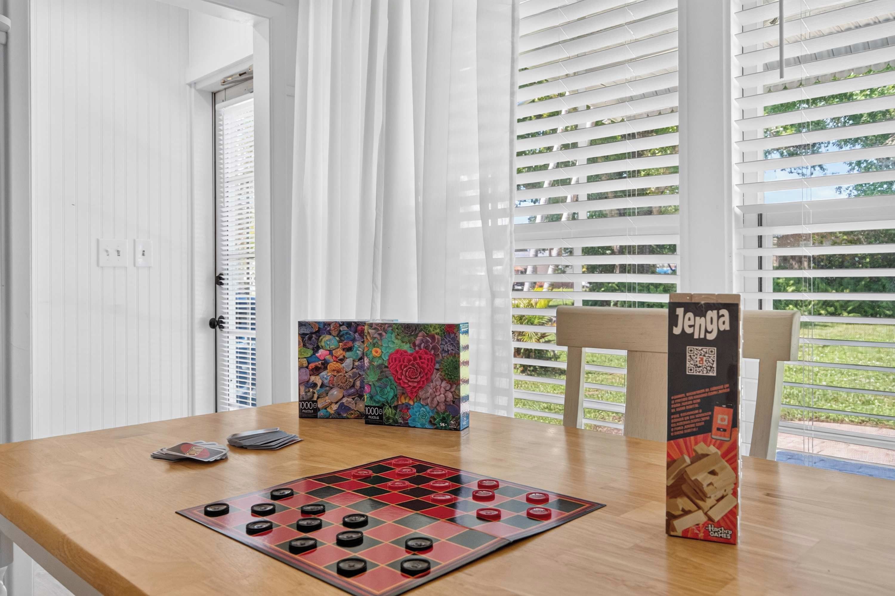 A room with a wooden table, a chessboard, and a Jenga box.