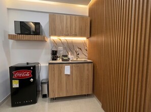 A compact kitchen with a microwave, a refrigerator, and a coffee maker. - Vrbo Property (Dosquebradas)