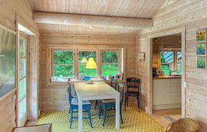 A wooden interior with a dining table, chairs, and a window with a view of greenery. - Lovely home in Tisvildeleje with WiFi (Tisvildeleje)
