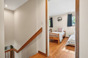 Ein Schlafzimmer mit einem hölzernen Bett, einem Nachttisch und einem an der Wand befestigten Regal.