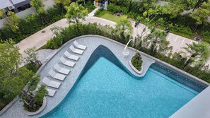 An aerial view of a swimming pool with lounge chairs and a surrounding garden. - Lumi 1br suite | Title Serenity Nai Yang (Tambon Sa Khu)