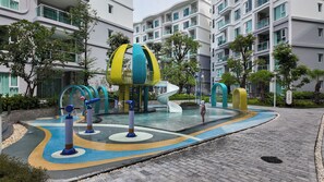 Un parc aquatique doté de toboggans et d’aires de jeux, entouré d’un immeuble d’habitation.