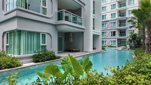 Un hôtel moderne doté d’une piscine entourée d’une végétation luxuriante.