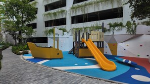 A children's play area with a slide, climbing wall, and soft play surfaces. - Lumi 1br suite | Title Serenity Nai Yang (Tambon Sa Khu)