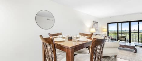 A dining area with a round table, chairs, and a mirror on the wall.