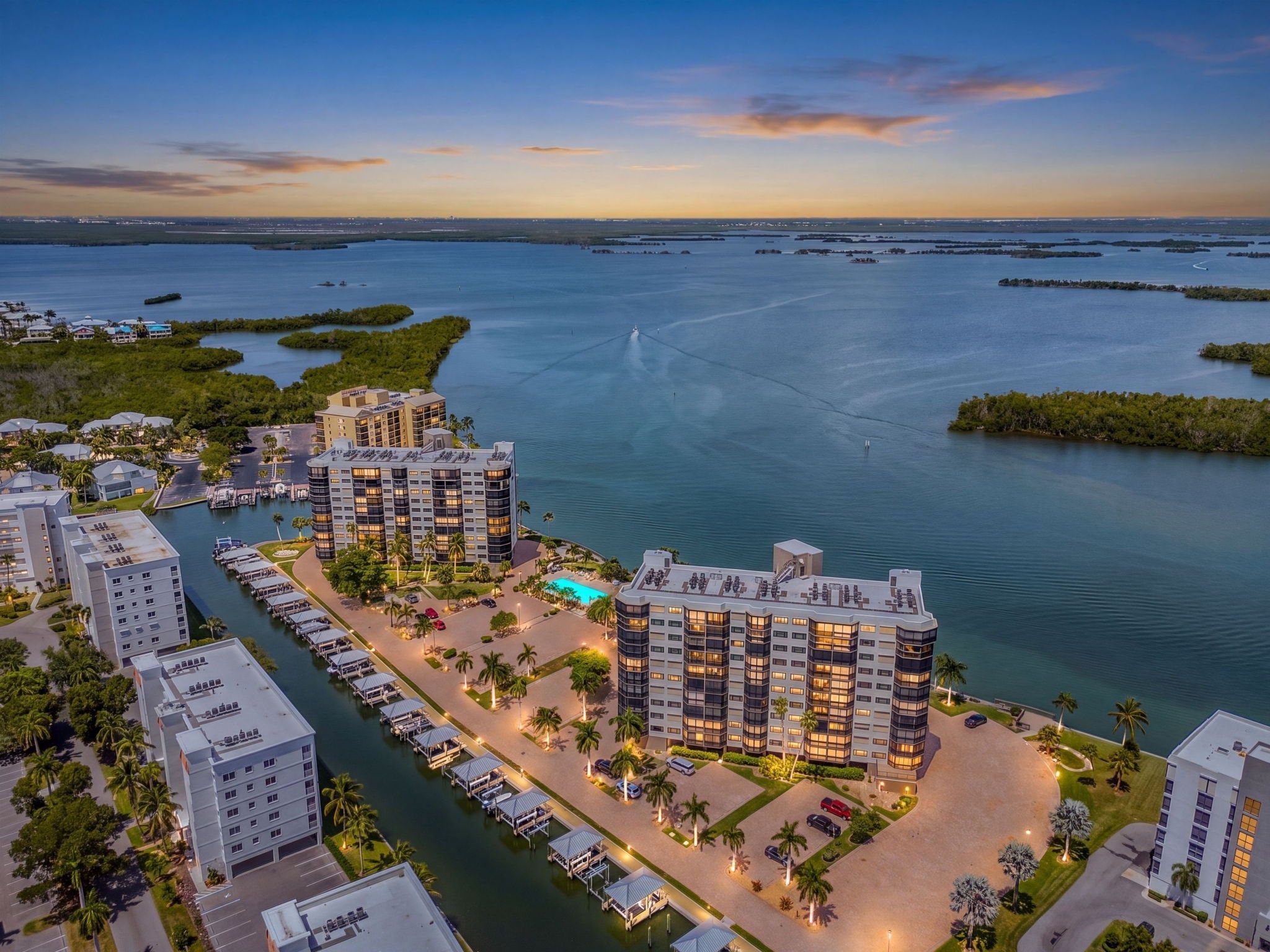 A waterfront hotel with multiple buildings, a marina, and a large body of water.