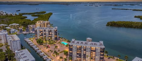 A waterfront hotel with multiple buildings, a marina, and a large body of water.