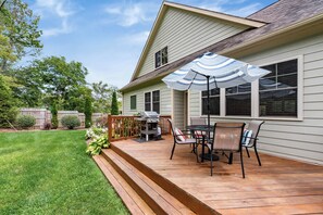 A deck with outdoor furniture and a grill, surrounded by a well-maintained lawn and a wooden fence. - Mountain Gem - Minutes to Downtown WJ - Shops - Hiking (West Jefferson)