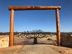 A wooden gate with a metal fence and a tree design, labeled '14 Oaks.' - 14 Oaks Ranch in Sierra Foothills; perfect for family getaways (Oroville)