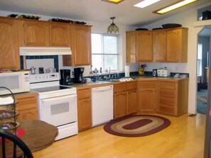 A kitchen with wooden cabinets, a microwave, a stove, and a dishwasher. - 14 Oaks Ranch in Sierra Foothills; perfect for family getaways (Oroville)