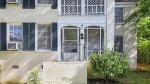 A two-story building with a front door, a small porch, and a mailbox.