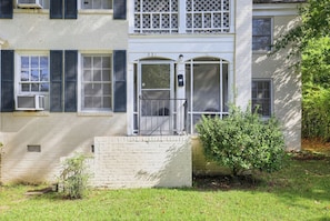 A two-story building with a front door, a small porch, and a mailbox.