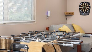 A room with a foosball table, a dartboard, and a sign indicating a game room. - Lake and Ski/Gameroom/Dogrun (Wofford Heights)