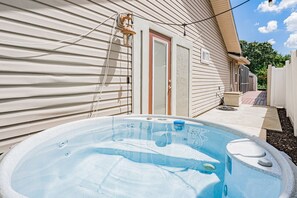 A backyard with a hot tub, a wooden deck, and a house with siding and a door. - 🐢Turtle Oasis | 4BR/ 2.5 bath | Largo retreat with pool and hot tub| Sleeps 8 (Largo)