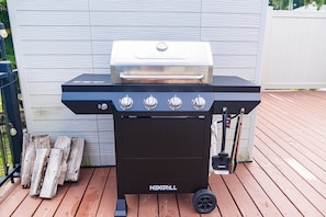 Una parrilla NEXGRILL para barbacoa con cuatro quemadores, un quemador lateral y un termómetro.