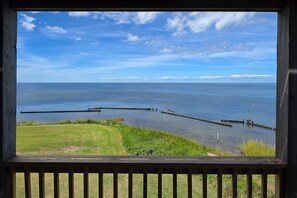 A view of a calm body of water with a wooden dock extending into it, surrounded by grassy areas. - 7522 - Island Thunder (Avon)