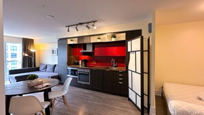 A modern apartment with a kitchen, dining area, and a bed. - StayToronto - CN Tower & Front St Suites (Toronto)