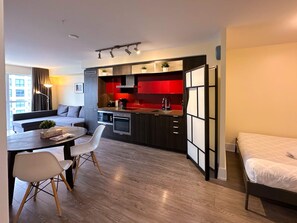 Um apartamento moderno com cozinha, sala de jantar e uma cama.