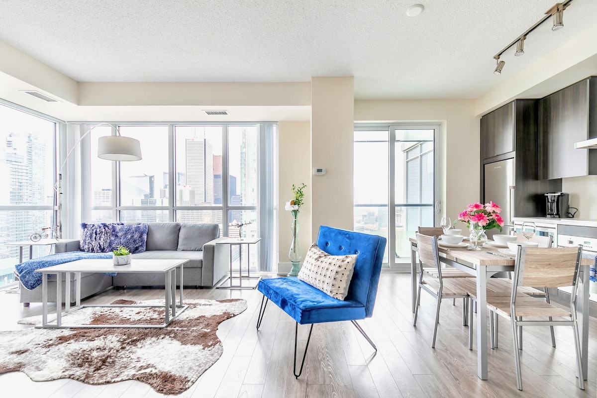 A modern living room with a sofa, coffee table, and dining area.