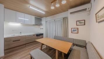A compact kitchen with a dining area, including a bench and a table.