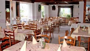 A dining area with multiple tables and chairs, arranged in a spacious layout. - Vrbo Property (Winterberg/Züschen)