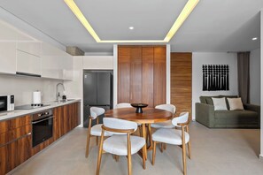 Una cocina moderna con comedor, horno empotrado y refrigerador.