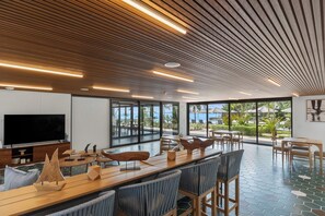 Un interior moderno con techo de madera, ventanas amplias y una zona de piscina.