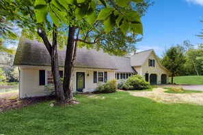 A two-story house with a front porch, a driveway, and a well-maintained lawn.