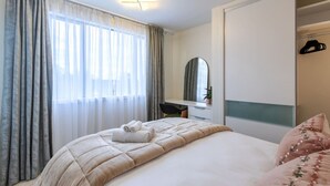 Un dormitorio con cama, escritorio, espejo y armario.