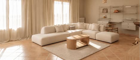 Una sala de estar moderna con un sofá modular, una mesa de centro y una estantería en la pared.