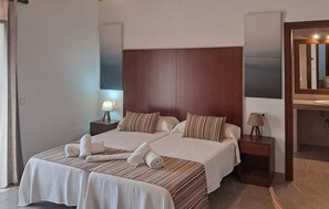 A hotel room with a large bed, two bedside tables, a nightstand, a mirror, and artwork on the walls. - Awesome home in Felanitx with sauna (Felanitx)