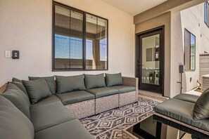 A modern living area with a sectional sofa, a patterned rug, and a dining area visible through a glass door. - Skyline 1753, Private Hot Tub, Resort Amenities, and Close to Sand Hollow! (Washington)