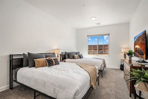 A bedroom with two beds, a window with a view, a television, and a plant. - Skyline 1753, Private Hot Tub, Resort Amenities, and Close to Sand Hollow! (Washington)