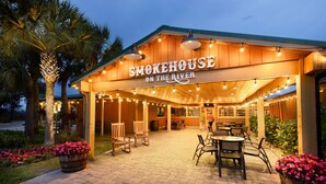 A restaurant named Smokehouse on the River with outdoor seating and string lights. - Waterfront RV Oasis: Dock & Pavilion | Lot 561 (River Ranch)