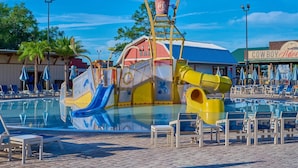 A water park with a large pool, slides, and a cowboy-themed building. - Waterfront RV Oasis: Dock & Pavilion | Lot 561 (River Ranch)