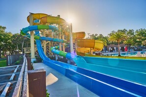 Een waterpark met verschillende glijbanen en een zwembad.