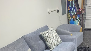 A grey sofa with patterned cushions in a room with a dark floor. -     Brand-New Luxury Home Spacious, Stylish & Your Home Away From Home (Tobyhanna)